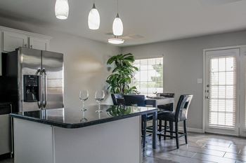 A kitchen with a bar and a table with chairs
